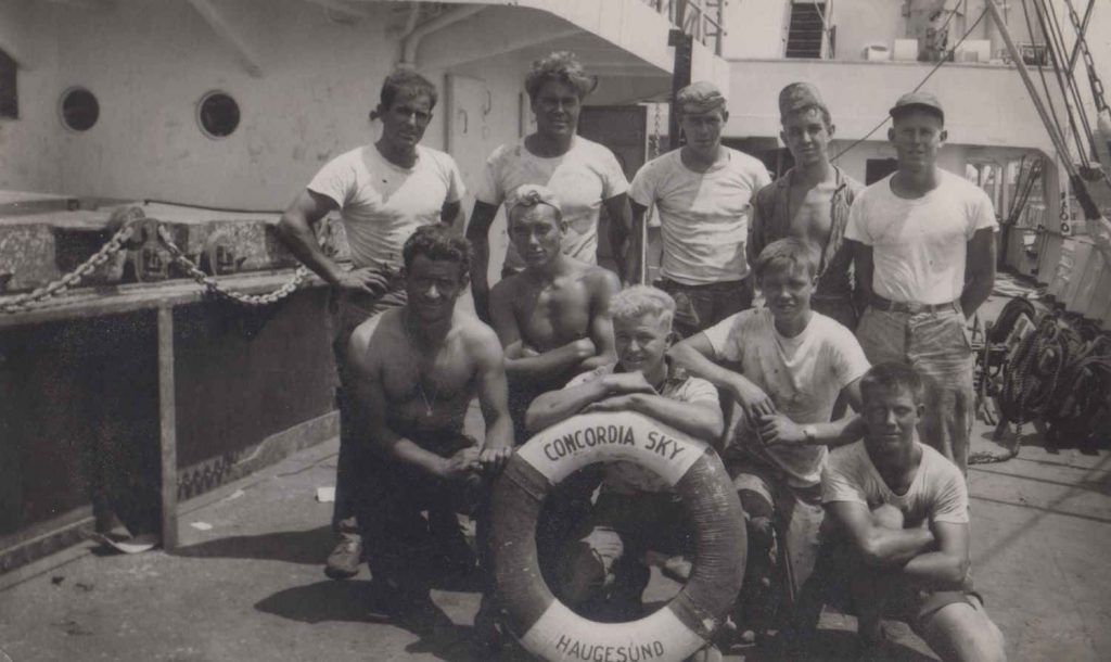Dag Albert Witzøe Molaug og dekksgjengen om bord i M/S "Concordia Sky" 1962/1963. Dag sittende med armene på livbøyen.